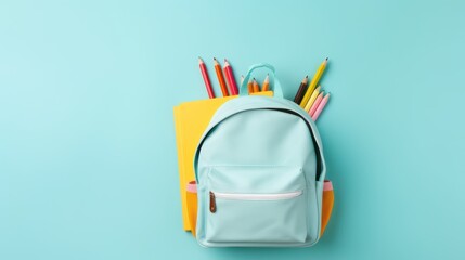 Blue elementary school child's backpack on a blue background, with stationary decoration. Copy space text template.