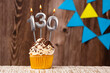 Birthday card with candle number 130 - Wooden background with pennants