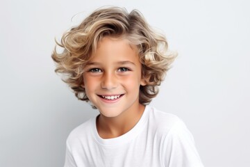 Wall Mural - Closeup portrait of a cute little boy with blond curly hair on a gray background