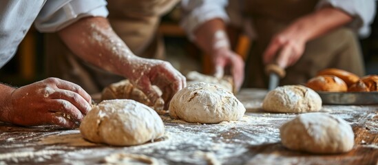 Wall Mural - Bakers preparing dough for homemade bread on a wooden table in close up view.