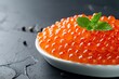 Salmon red caviar presented on a white plate against a dark backdrop embodying a healthy seafood snack