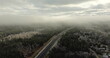 Aerial View of Misty Winter Morning Over Finland's Tranquil Forest Road