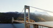 Majestic Suspension Skjombrua Bridge Spanning Over Tranquil Waters Against a Mountainous Backdrop at Sunset