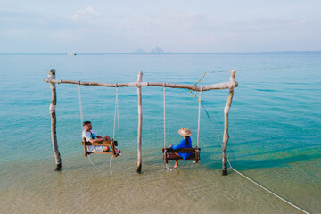 Wall Mural - a couple of men and woman on a swing at the beach of Koh Muk Thailand