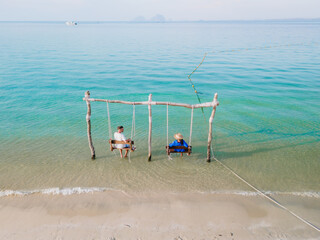 Wall Mural - a couple of men and woman on a swing at the beach of Koh Muk Thailand