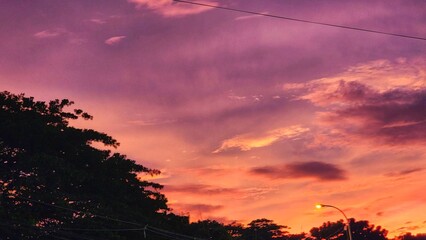 a purple sky with clouds and street lights