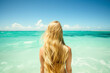© kazakova0684 - young blonde woman walks into turquoise sea water, rear view