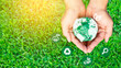 Businessman holding green scrap paper ball with world map and environment icon, Sustainable development and green business based on renewable energy.Net Zero and Carbon Neutral Concepts.