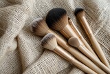 Fototapeta Sypialnia - Eco-friendly makeup brushes made of bamboo displayed on a natural burlap fabric background