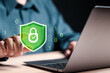 © Pakin - Protection network security and information security system concept, Businessman use laptop with virtual shield protect icon.