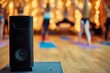 speaker on a yoga mat with blurred figures doing dance yoga in a studio