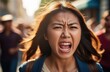 angry asian protester screaming on street. female activist protesting against rights violation.