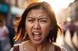 young activist protests against rights violation. angry asian female protester screaming on street.