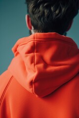 Poster - A man wearing an orange hoodie gazes off to the side. Suitable for various uses