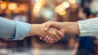 Partnership in Focus: Close-Up of a Firm Handshake Against Blurred Lights