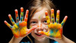 Close-up of a freckled girl with a colorful painted hand, black background enhancing the colors
