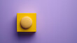 a blank yellow box of powder foundation with a sponge applicator on a purple background 
