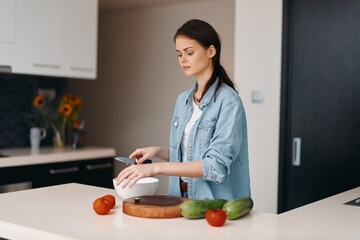 Wall Mural - Fresh and Healthy: A Young, Attractive Caucasian Female Cooking a Vegetarian Meal in her Home Kitchen