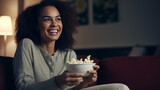 Fototapeta Konie - Cheerful lady having popcorn while watching TV