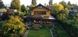 Eagle view of a craftsman house in a rich marigold, with a backyard boasting a sun-themed solarium and a geometric flower bed.