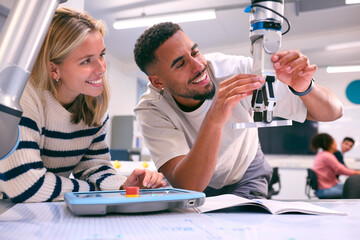 Male And Female College Or University Engineering Students In Robotics Class Working Together