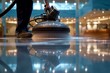 A cleaning operative expertly maneuvers a high-speed polishing machine, humming as it revives a dull floor into a gleaming walkway.