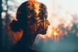 A double exposure effect creatively merges the outline of a woman's head with the lively details of a forest basking in the sunrise's glow