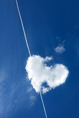 Wall Mural - heart shaped clouds in blue sky with plane trace.