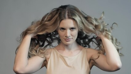 Wall Mural - Slow motion video of woman throws up long curly hair with hands. Female hair beauty concept.