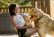 © Ievgen Skrypko - Girl Sitting Near House Petting Golden Retriever Dog, Taking Paw