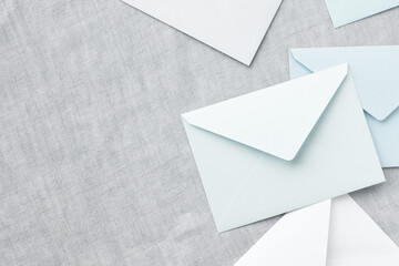 Wall Mural - blue and white envelopes are randomly placed on a gray tablecloth, leaving a copy space on the left