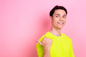 Canvas Print - Photo portrait of nice teen man point look empty space toothy smile wear trendy yellow clothes isolated on pink color background