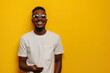 Portrait of toothy beaming nice African American man wear stylish t-shirt in eyewear hold smartphone arm in pocket isolated on color background