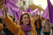Women smile at the camera during a demonstration. they protest with purple flags