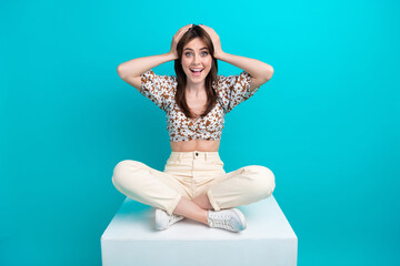 Sticker - Photo of impressed funky woman wear flower print top sitting podium arms head isolated teal color background