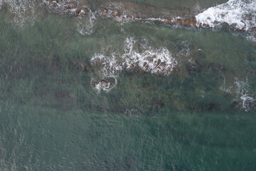 Canvas Print - Ocean coast with brown rocks