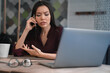 © InsideCreativeHouse - Busy woman sitting at her workplace and discussing with gesticulation some job questions on mobile phone in hand. Multitasking, deadline and workload