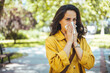Woman Blowing Her Nose With Handkerchief In Public Parkf. Sick Young Woman With Seasonal Influenza Blowing Her Nose On A Tissue. 