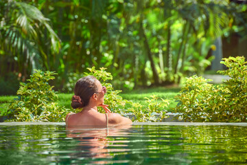 attractive woman relaxing on a spa's swimming pool.