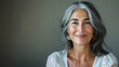 © Nataliia_Trushchenko - Happy smiling stylish confident 50 years old Asian female professional standing looking at camera at gray background. Portrait of sophisticated grey hair woman advertising products.