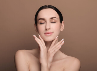 Portrait of beautiful young woman on brown background