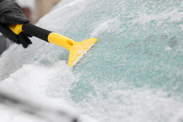 Wall Mural - Man cleaning snow from car windshield outdoors, closeup