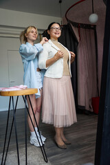 Craftswoman helps a client try on a light jacket