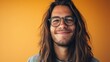 © Z A C - Smiling man with long hair and glasses against orange background.