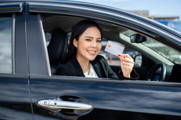 Wall Mural - Young beautiful asian business women getting new car. Hand holding credit card payment. Car owner paying fuel pump with credit card customer mileage point loyalty reward. Driving vehicle on the road