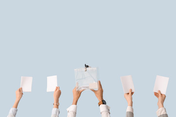 Hands holding ballot box and voting papers on light background. Election concept