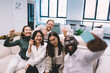 © BullRun - Cheerful multiethnic colleagues taking selfie on couch