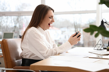 Canvas Print - Stressed young businesswoman with alarm clock at table in office. Time management concept