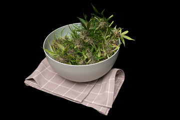 Wall Mural - Green ripened blossom of marijuana flower on dish towel with black background