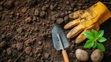 Fototapeta  - A pair of garden gloves and a trowel laid on freshly turned soil